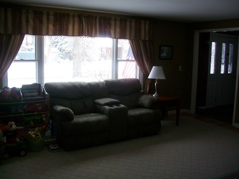 A living room with a grey couch and a lamp.