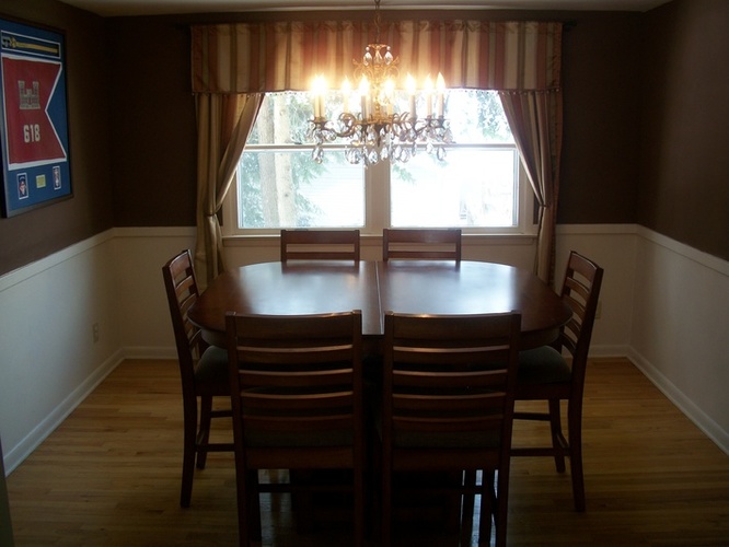 A dining room with a wooden table and chairs.