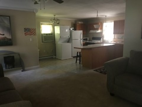 A kitchen with a refrigerator and a dining table.
