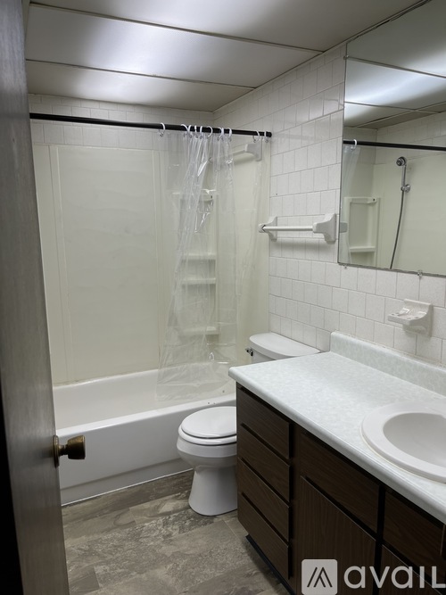 A bathroom with a toilet, sink, and shower.