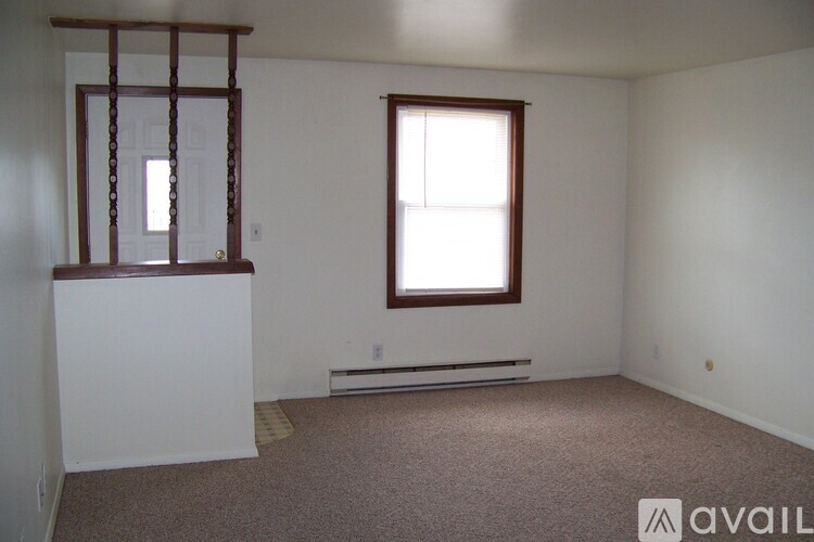 A room with a window and a bench under it.