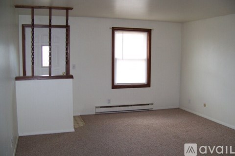 A room with a window and a bench under it.