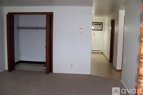 A room with a carpeted floor and a white wall.