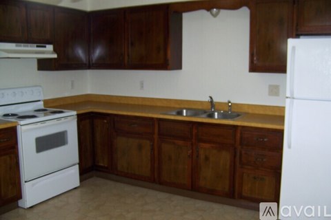 A kitchen with wooden cabinets and a white stove.