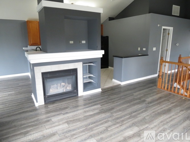 A living room with a fireplace and a wooden floor.