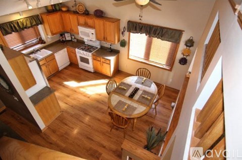 A kitchen with wooden floors and a table with chairs.