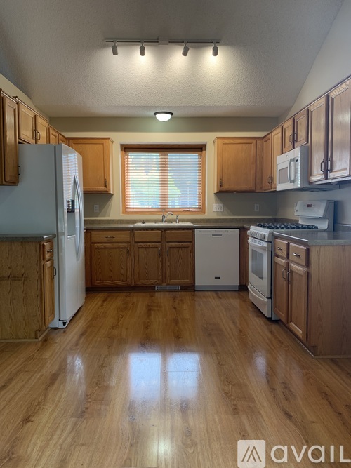 A kitchen with wooden cabinets and a white fridge.
