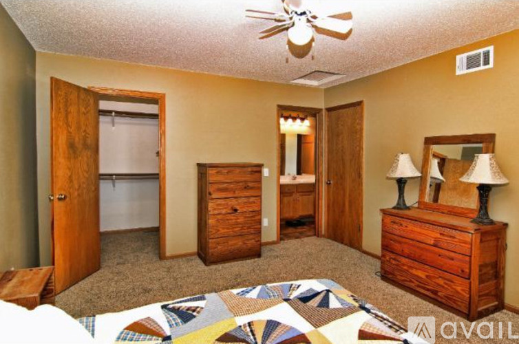 A bedroom with a bed, dresser, and mirror.
