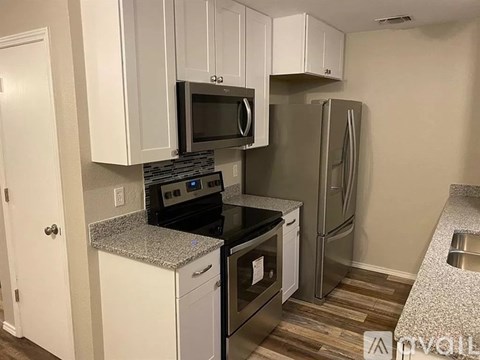 A kitchen with white cabinets and stainless steel appliances.