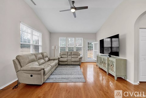 A living room with a grey sofa and a television on a cabinet.