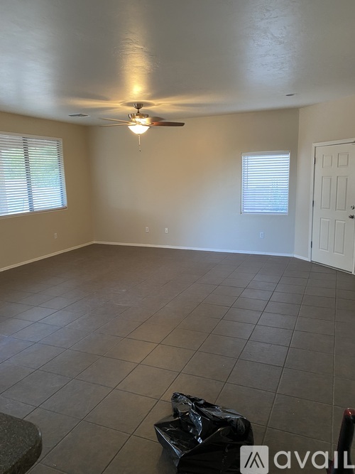 A room with a ceiling fan and tile flooring.