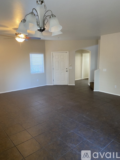 A room with tile flooring and a chandelier.