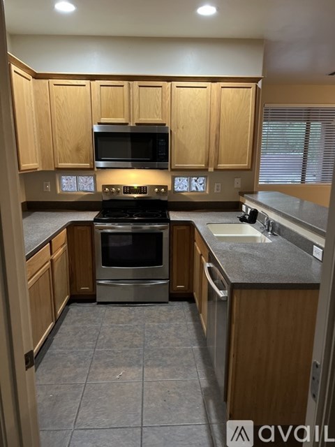 A kitchen with wooden cabinets and a black stove top oven.