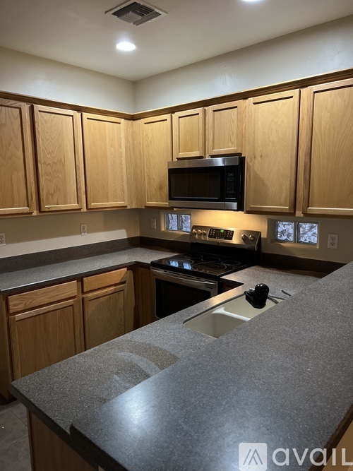 A kitchen with wooden cabinets and a granite countertop.