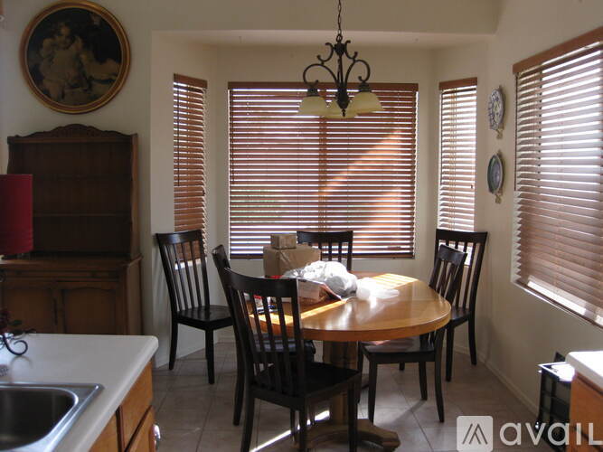 A dining room with a table surrounded by chairs.
