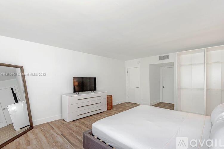 A bedroom with a bed, dresser, and mirror.