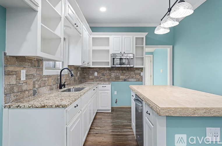 A kitchen with white cabinets and a granite countertop.