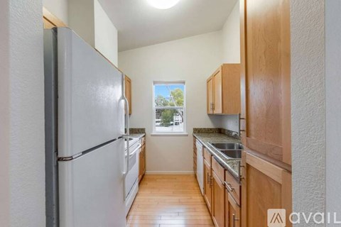A kitchen with wooden cabinets and a white refrigerator.