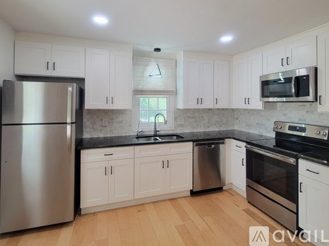 A kitchen with white cabinets and stainless steel appliances.