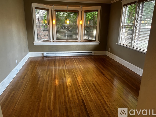 A room with wooden floors and two windows.