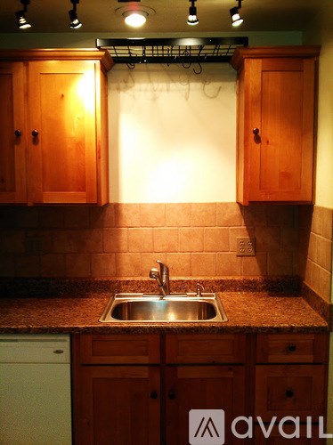 A kitchen with wooden cabinets and a granite countertop.