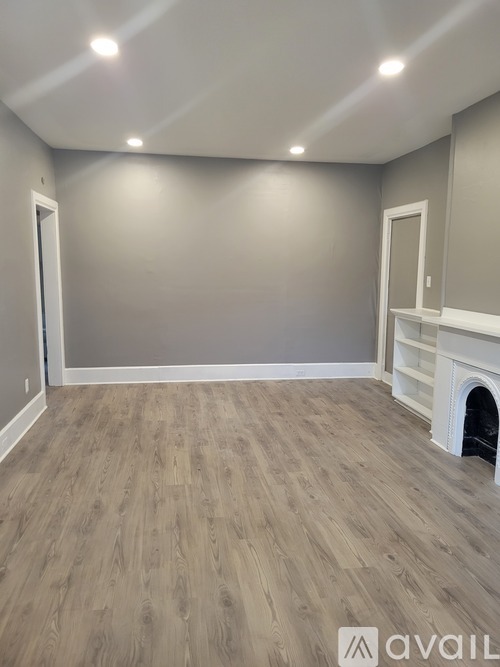 A room with a fireplace and wooden flooring.