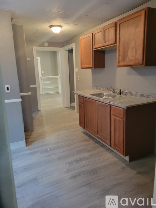 A kitchen with wooden cabinets and a marble countertop.