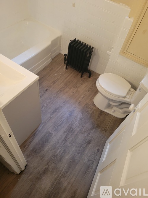 A bathroom with a toilet, sink, and a radiator.