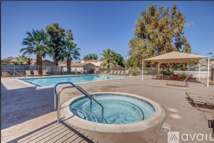 A pool with a hot tub and a fence surrounding it.