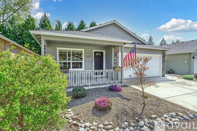A house with a front yard and a flag on the porch.