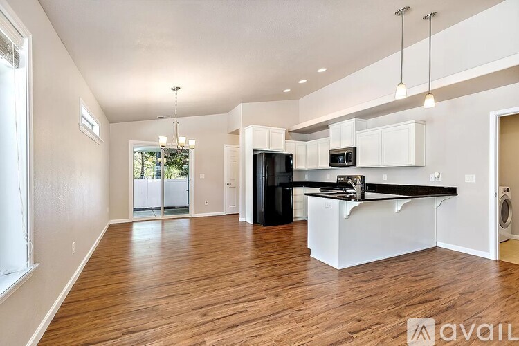 A spacious kitchen with white cabinets and a black countertop.