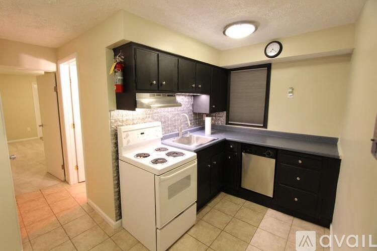 A kitchen with black cabinets and a white stove top oven.