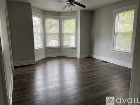 A room with wooden floors and a ceiling fan.