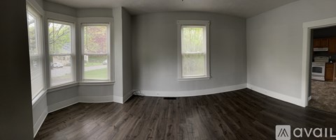 A room with wooden floors and two windows.