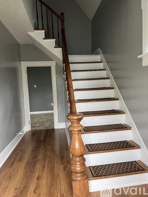 A wooden staircase with a white landing.