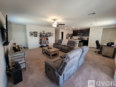 A living room with a grey couch and a television on the left side.