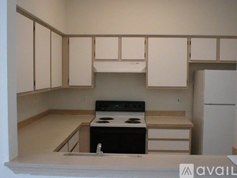 A kitchen with white cabinets and a black stove top oven.