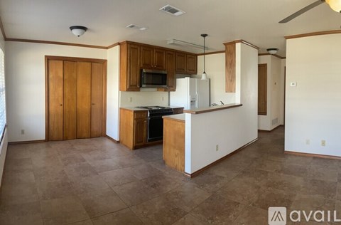 A kitchen with wooden cabinets and a tiled floor.