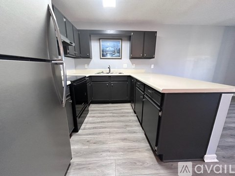 A kitchen with black cabinets and a white countertop.