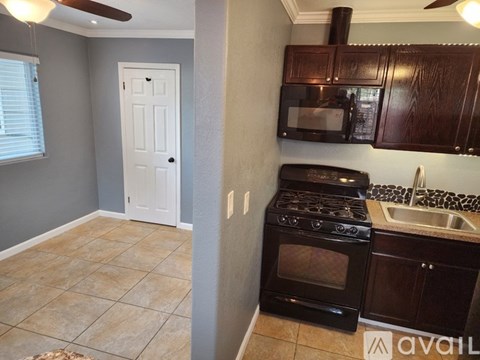 A kitchen with a black stove top oven and a white door.