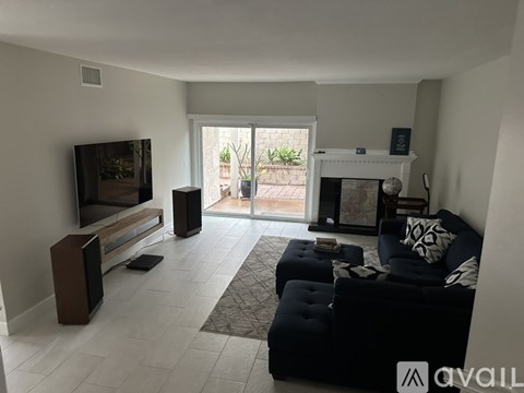 A living room with a black couch and a television.
