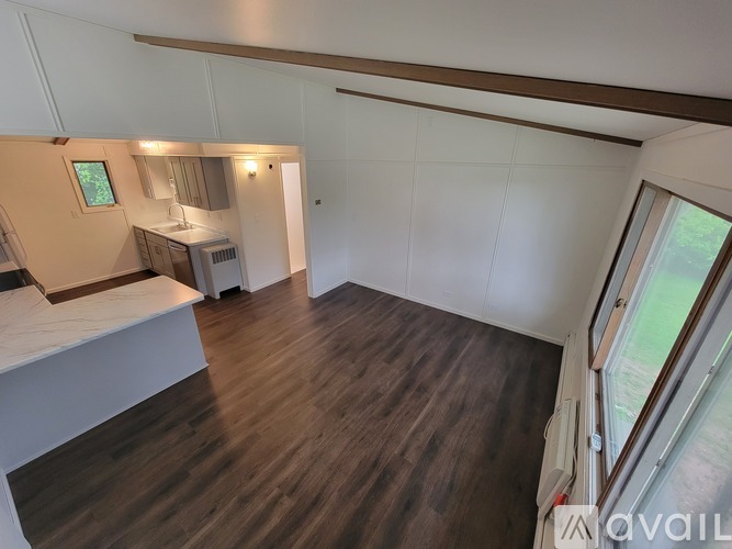 A room with wooden flooring and white walls.