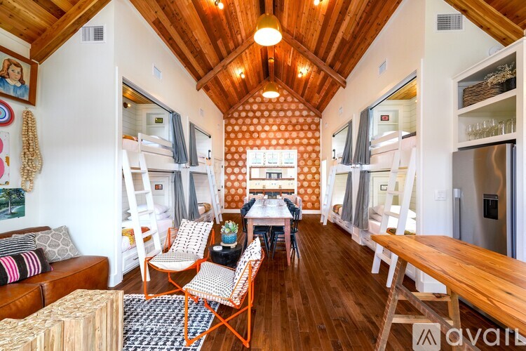 A living room with a wooden ceiling and a dining table with chairs.