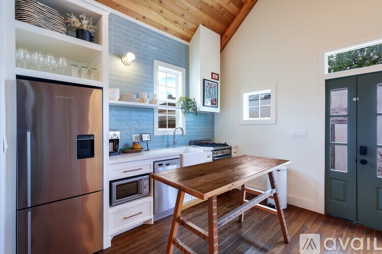 A kitchen with a wooden table and a refrigerator.