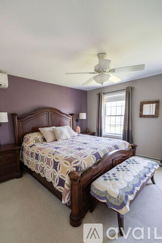 A bedroom with a bed and a window.