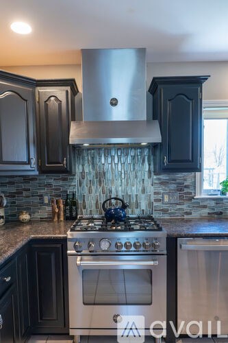 A kitchen with a stove top oven and a range hood.