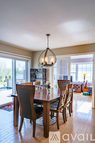 A dining room with a wooden table and chairs.