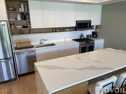 A kitchen with a marble countertop and stainless steel appliances.
