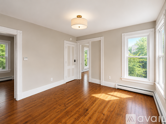 A large empty room with wooden floors and white walls.