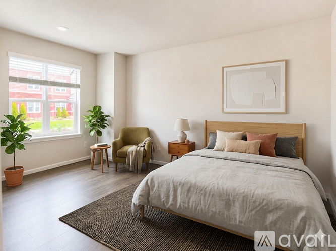 A bedroom with a large bed and a chair by the window.